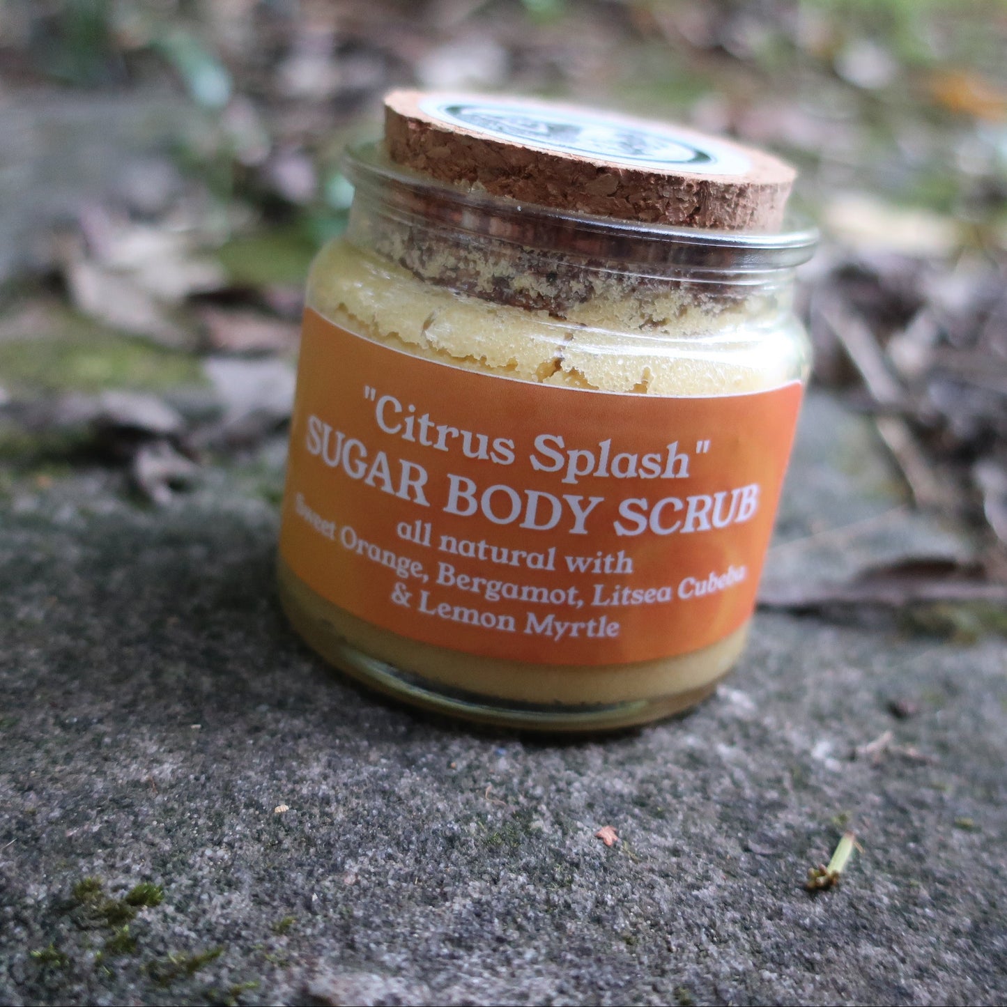 Jar of 'Citrus Splash' sugar body scrub on a stone surface with a natural background