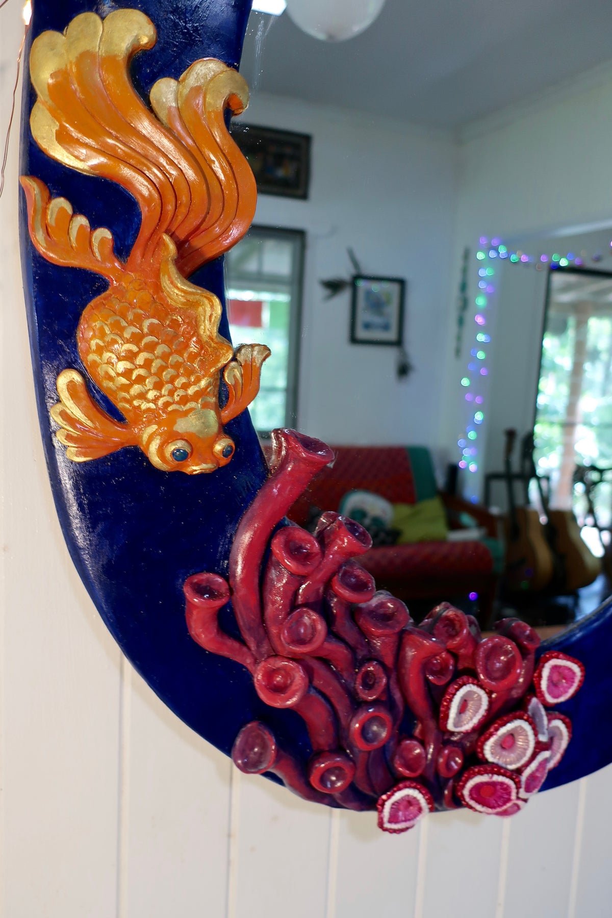 Close up picture of one of the small sculpted gold fish on large oval mirror