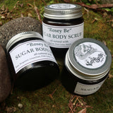 Three jars of Rosy Body products on a textured surface with leaves.