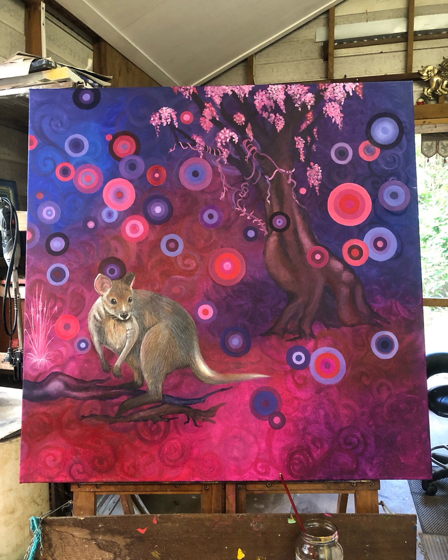 Colorful abstract painting of a kangaroo and tree with pink and purple hues.