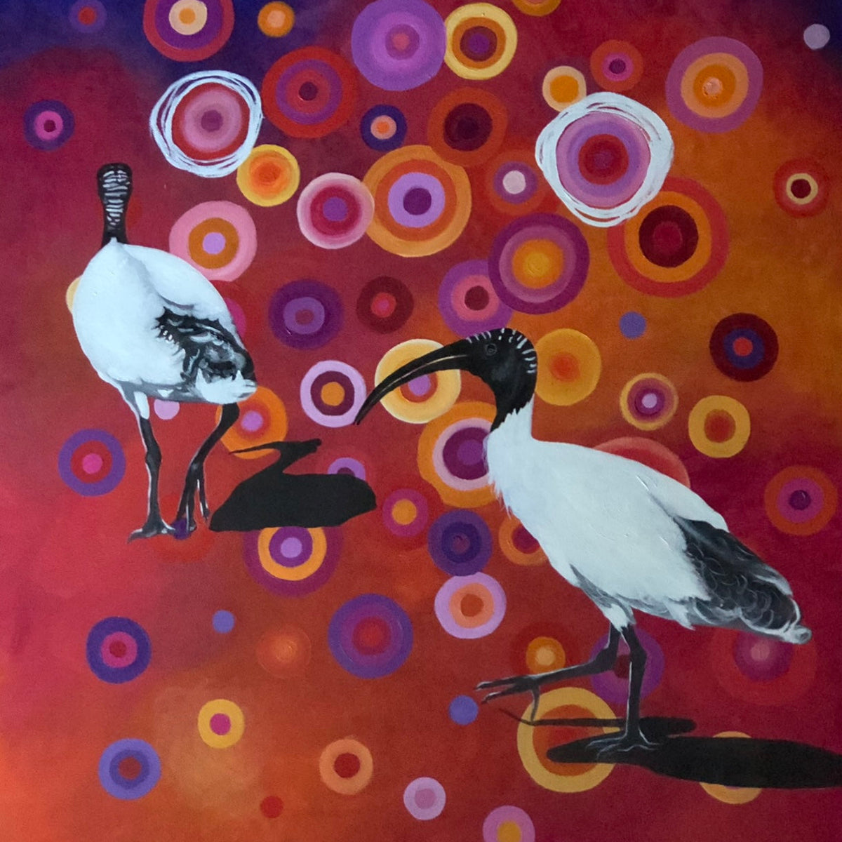 Two birds on a branch with a colorful circular pattern background