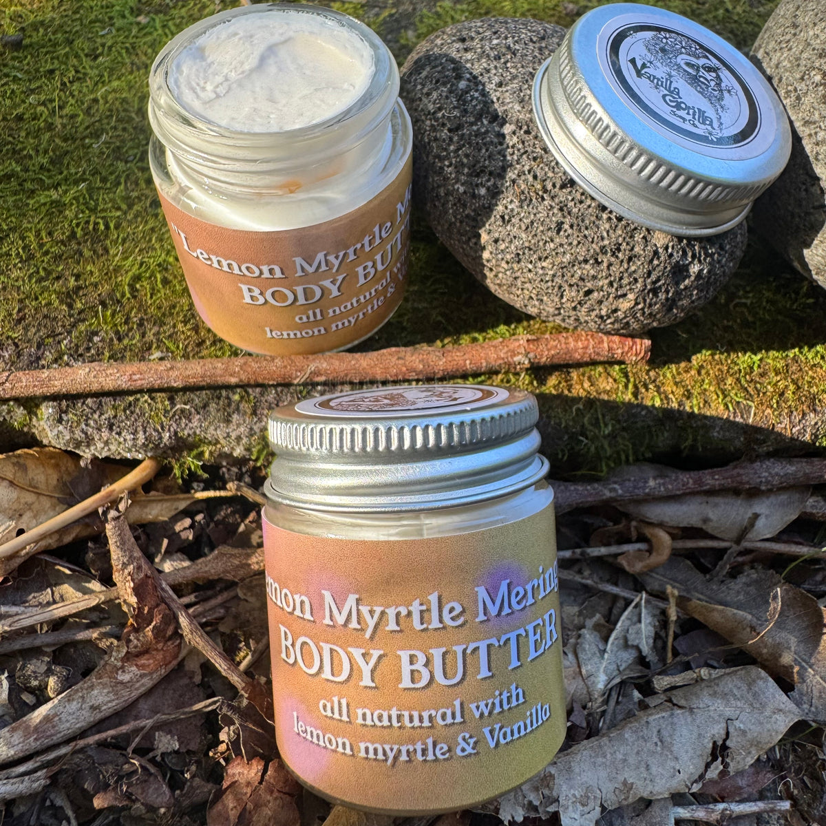 Jars of Lemon Myrtle Meringue body butter with lemon Myrtle and vanilla on a natural background with stones and leaves.