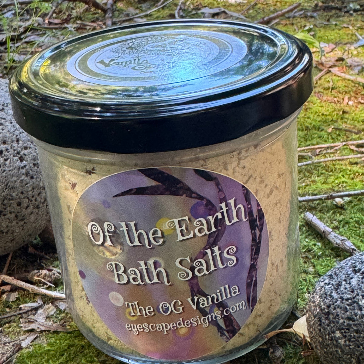 Jar of 'Of the Earth Bath Salts' with a black lid on a natural background