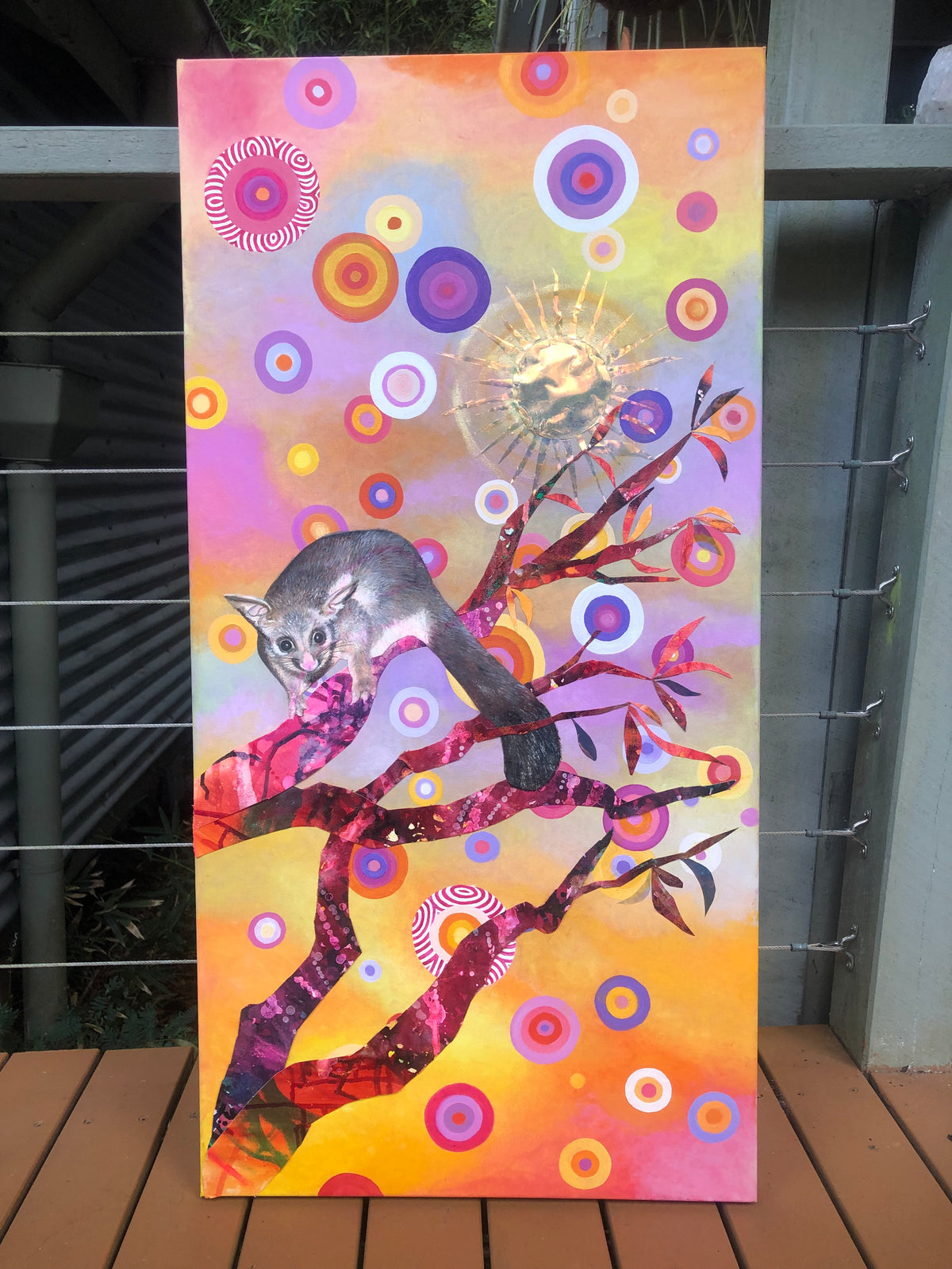 Colorful abstract artwork with a possum and tree design on a wall.