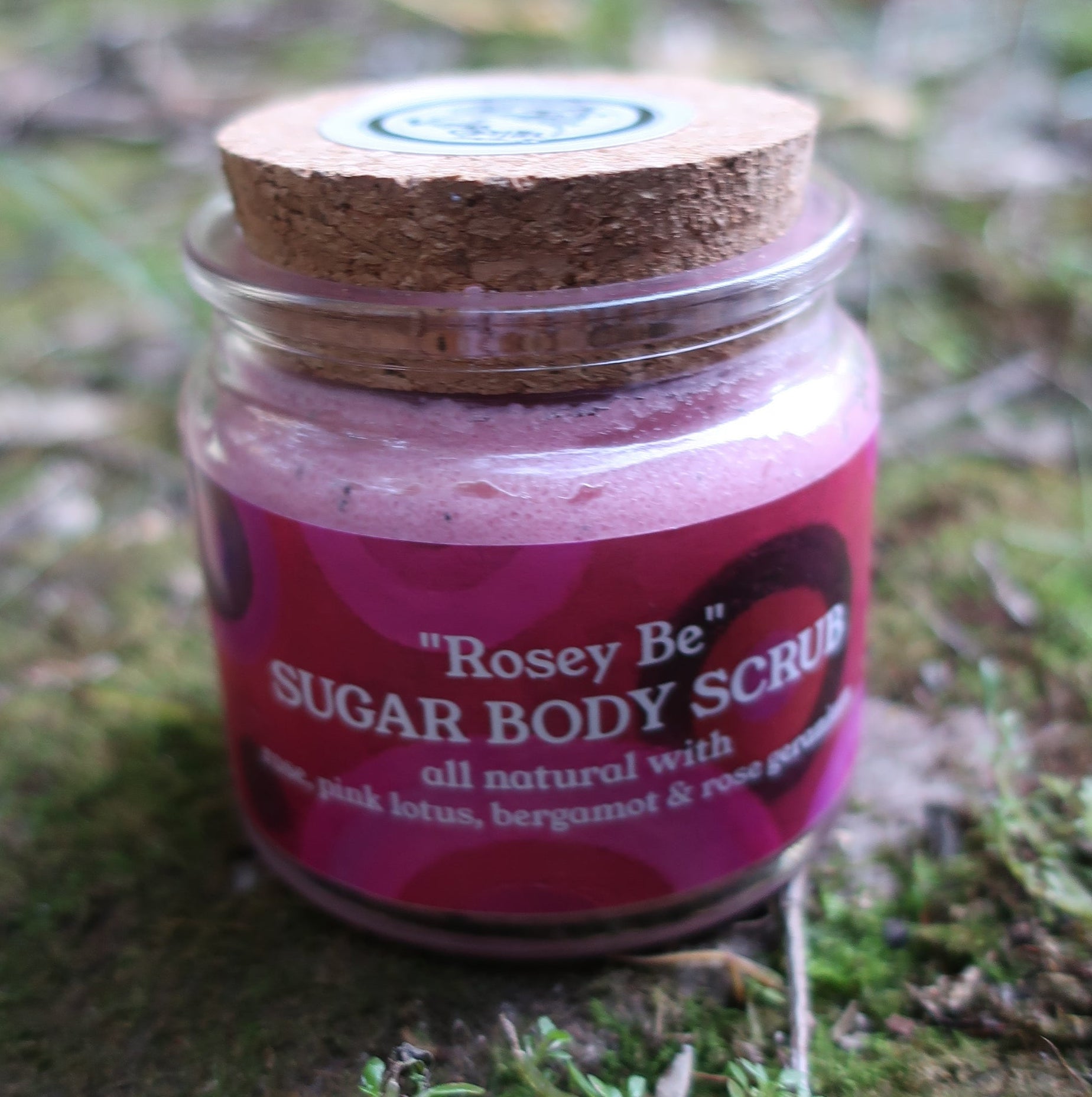 small Jar of vanilla gorilla sugar body scrub on a mossy surface with blurred natural background