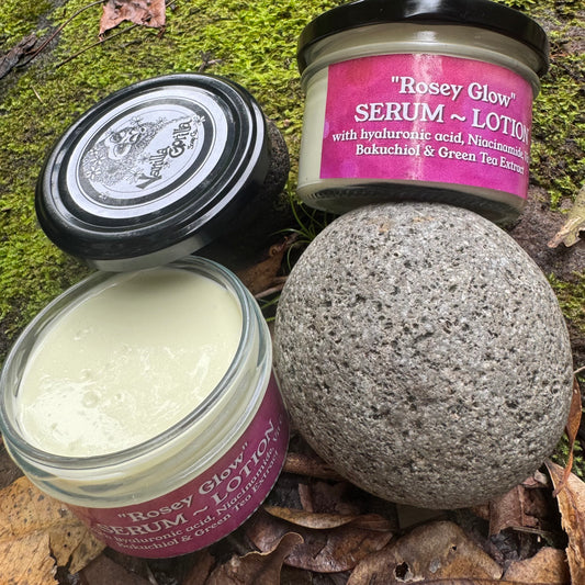 Two jars of 'Rosey Glow' serum and lotion on a natural background with a stone ball.