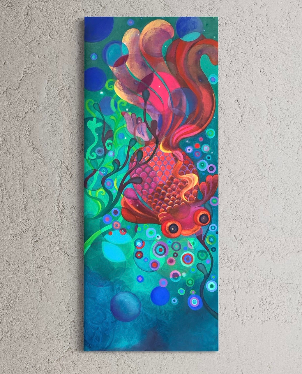 A colorful oil painting on canvas featuring a colourful abstract fish design, hanging on a grey textured wall