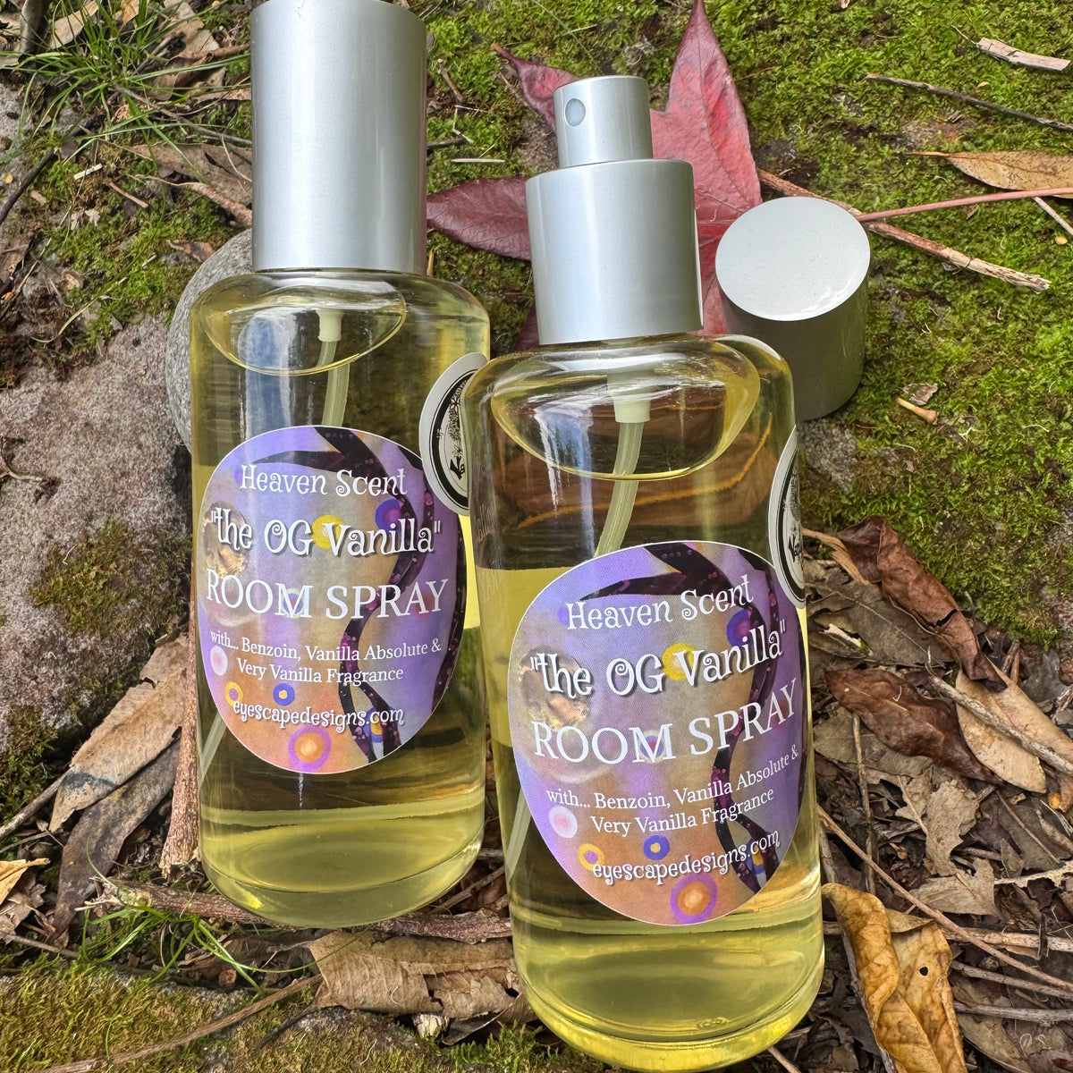 Two bottles of 'The OG Vanilla' room spray on a natural background with leaves and moss.