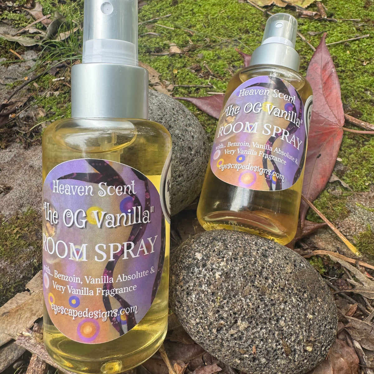 Two bottles of 'The OG Vanilla' room spray on a natural background with rocks and leaves.
