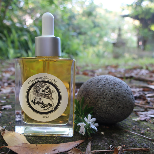Bottle of golden body oil oil with a dropper on a natural background