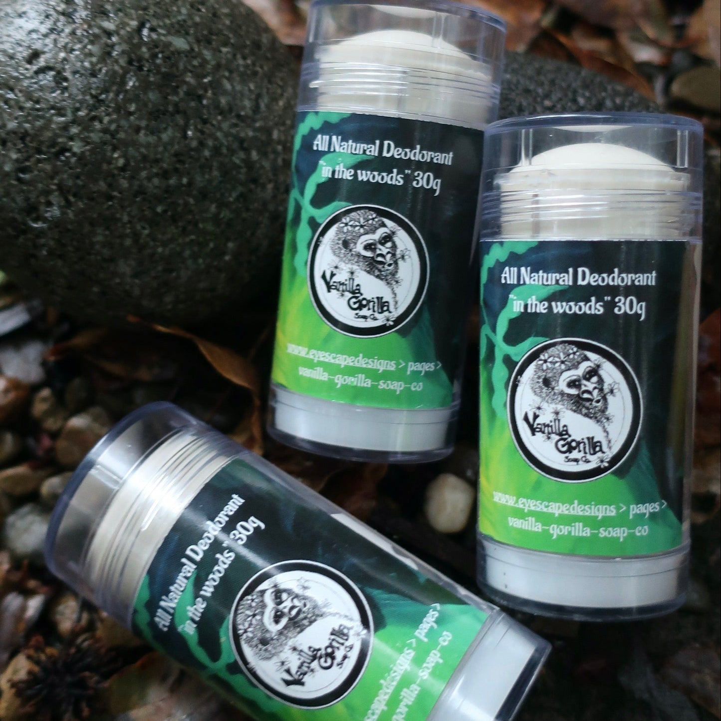 Three all-natural In the Woods deodorant sticks with visible branding on a natural background.