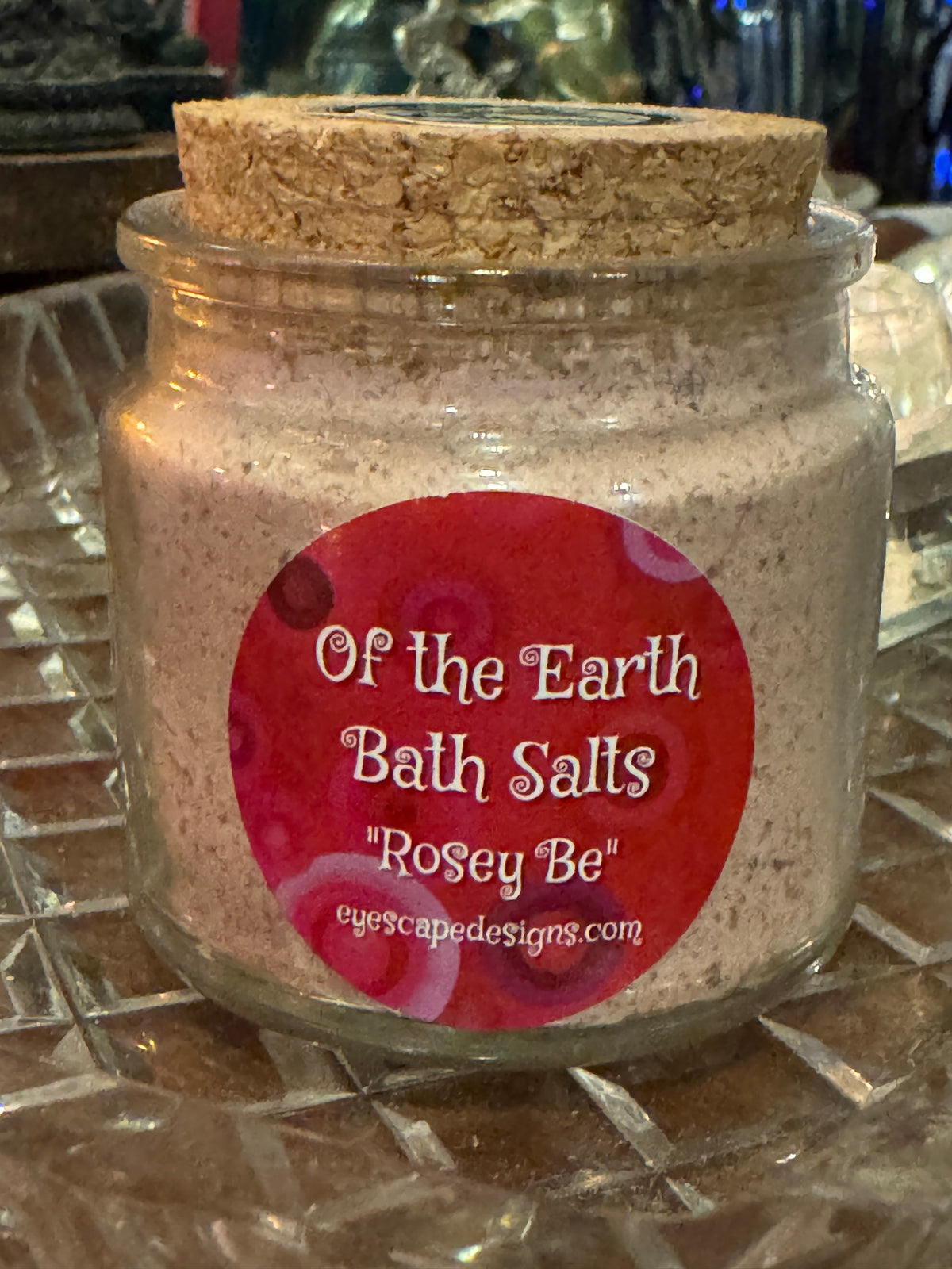 Jar of bath salts with a red label on a textured surface