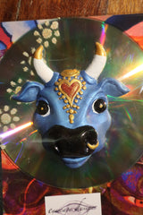 blue holy cow fridge magnet mounted on a CD
