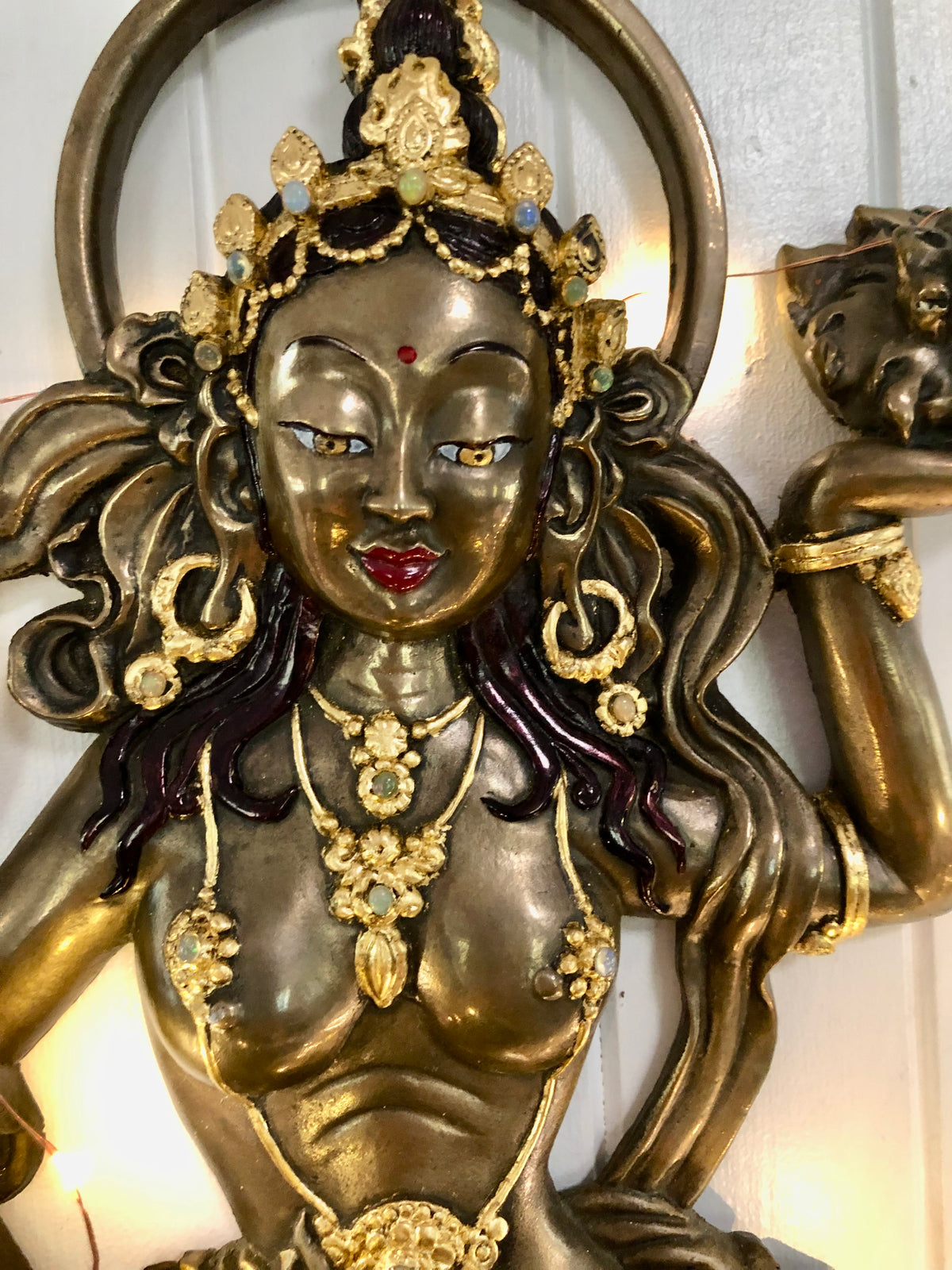 Close up of bronze offering goddess wth 24ct gold highlights 