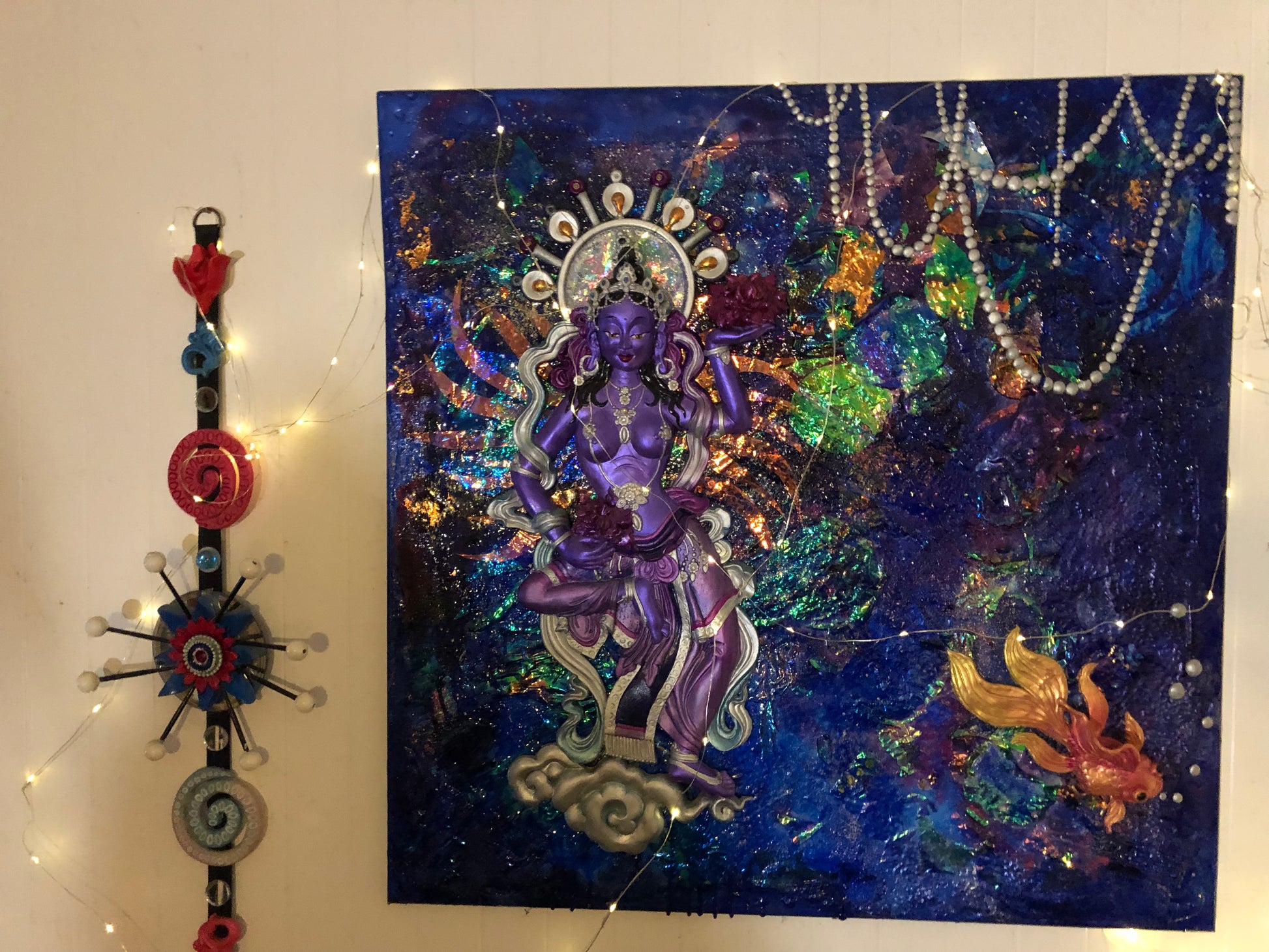 Dakini in a watery blue sea of irridescent galaxy with a gold fish
