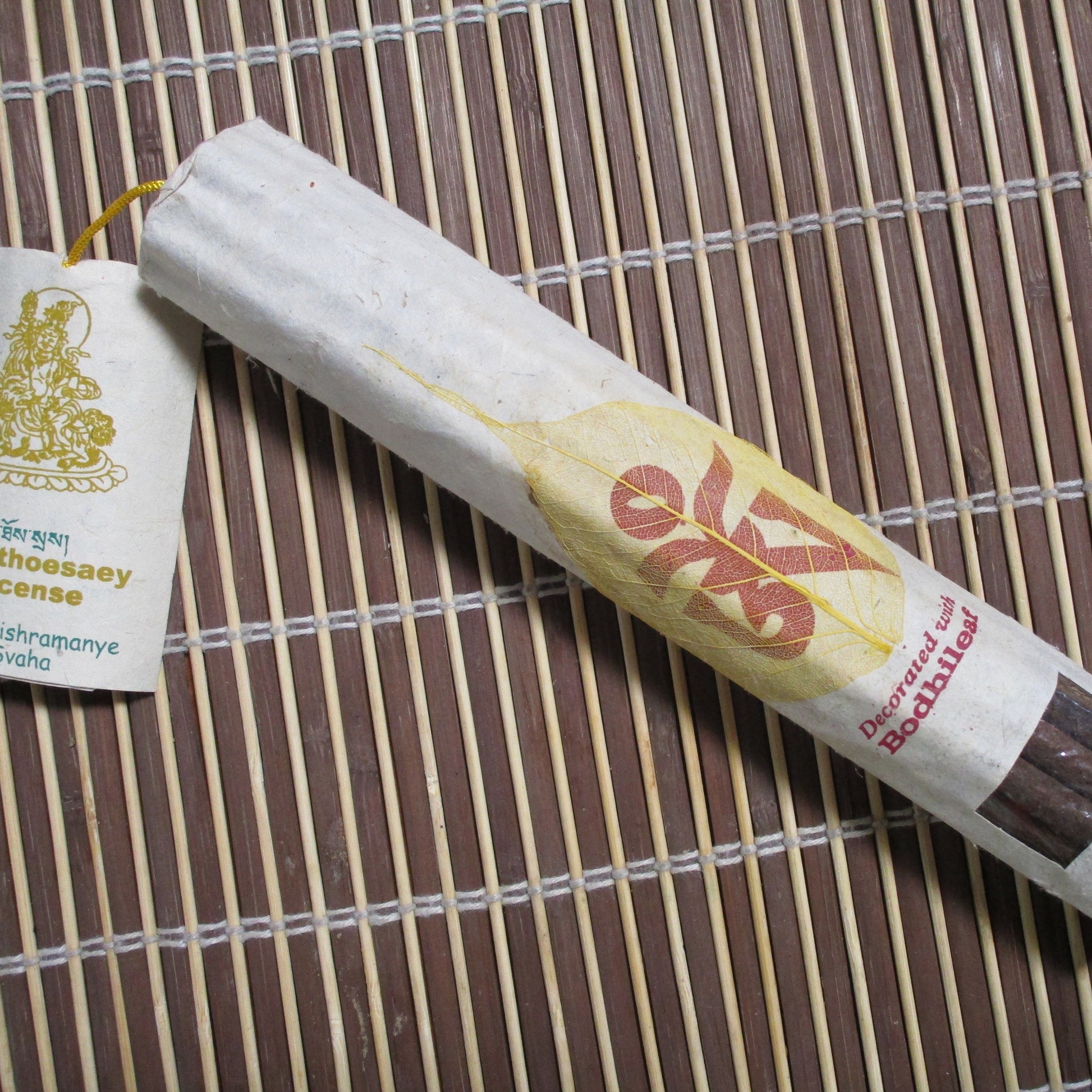A pack of Namthoesaey incense with a few sticks visible outside the packaging, which is predominantly gold and yellow with text.